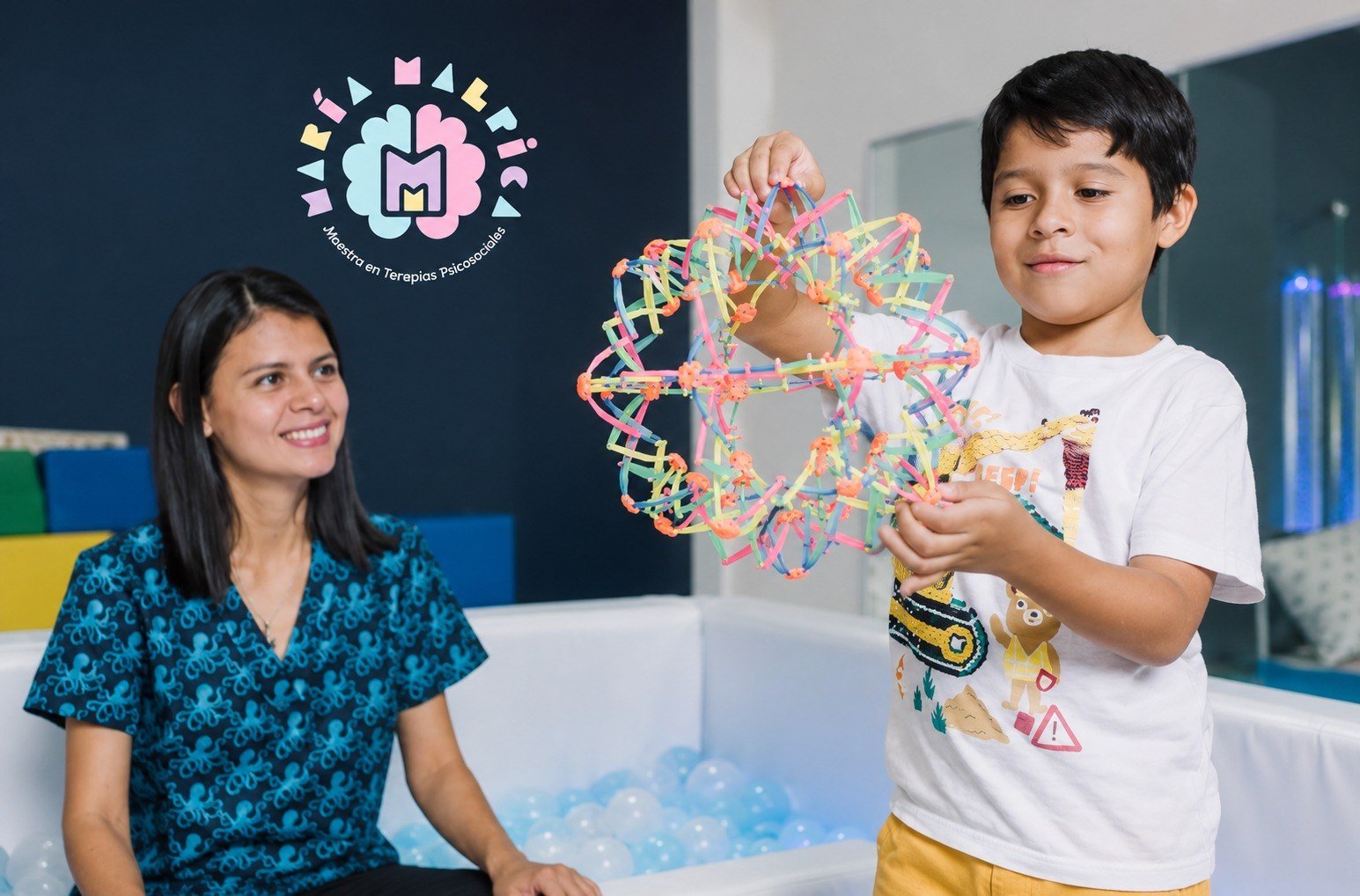 Niño explorando material visual y táctil con acompañamiento profesional en terapia multisensorial