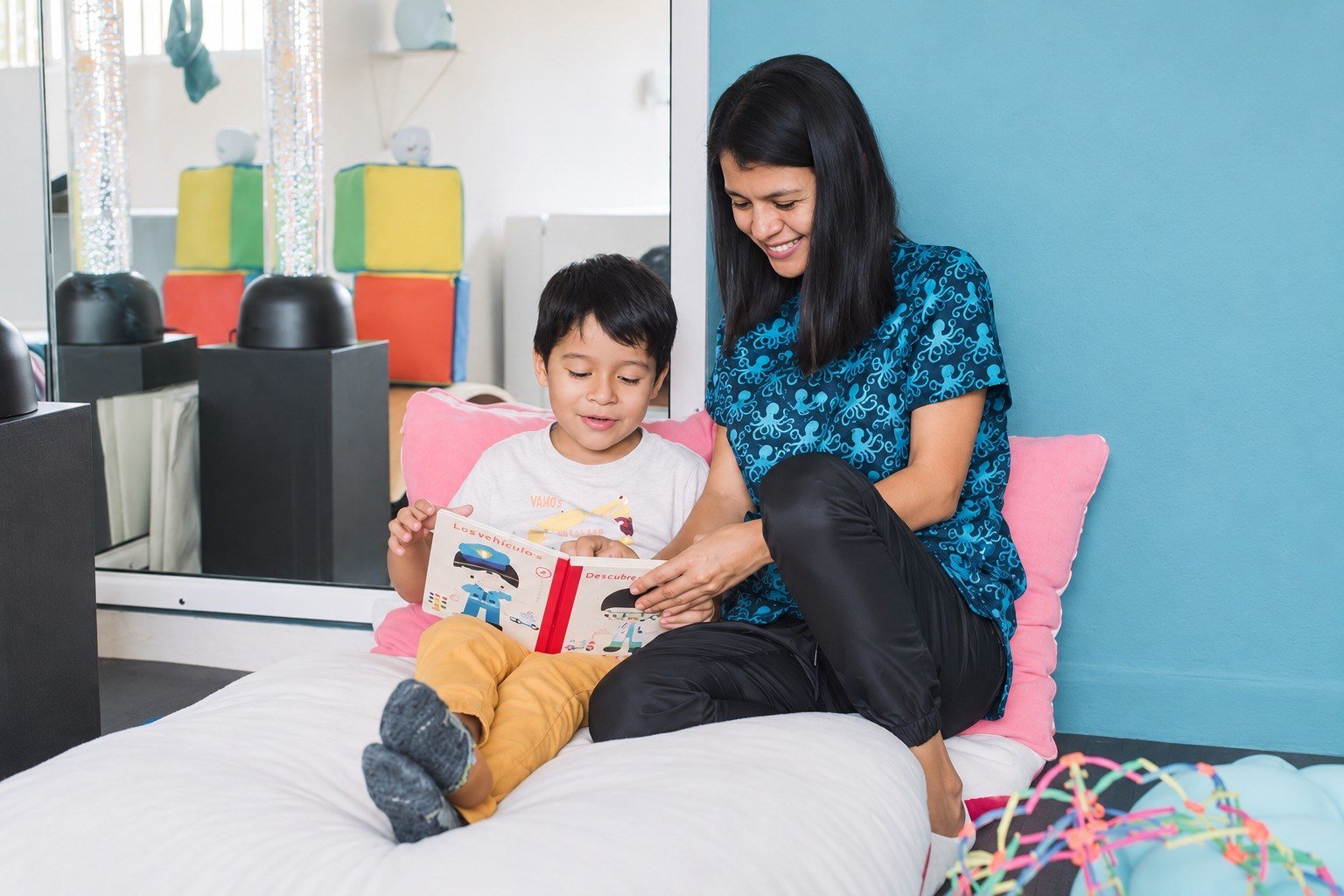 Psicóloga compartiendo lectura con un niño para favorecer comunicación, expresión emocional y vínculo terapéutico