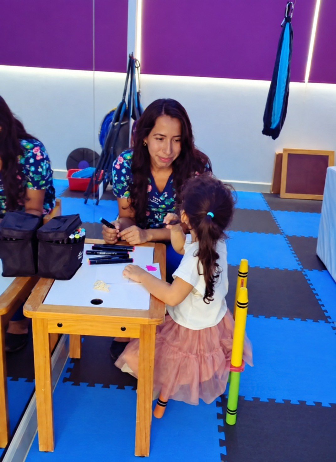 Psicóloga acompañando a una niña durante una actividad estructurada de psicoterapia infantil con enfoque cognitivo conductual